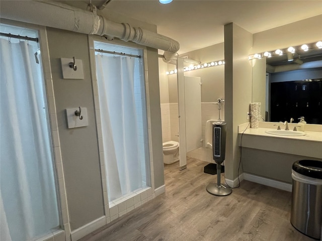 bathroom with oversized vanity, a shower with shower curtain, wood-type flooring, and toilet