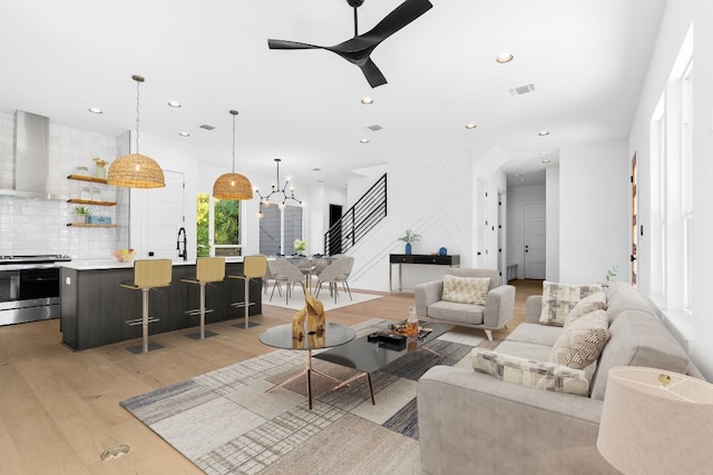 living room with light hardwood / wood-style flooring, ceiling fan, and sink