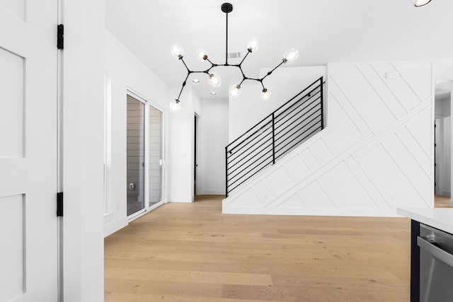 interior space with a notable chandelier and light hardwood / wood-style floors