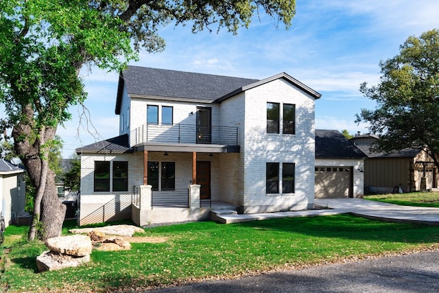 view of front of property with a front yard, a porch, a balcony, and a garage