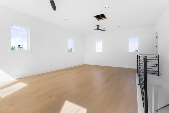 empty room with a wealth of natural light, ceiling fan, and light wood-type flooring