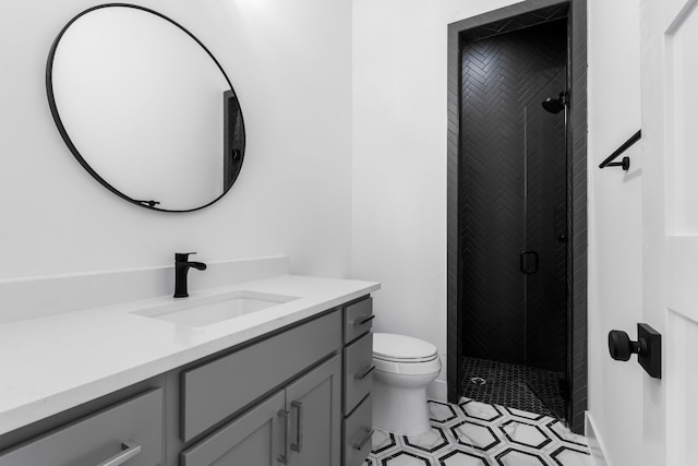 bathroom featuring vanity, toilet, and an enclosed shower