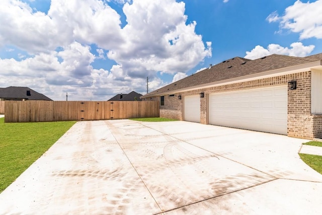 view of side of property with a garage and a lawn