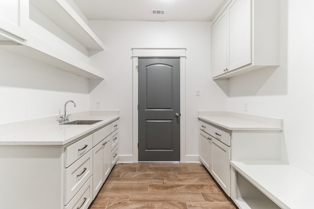 kitchen featuring white cabinetry and sink