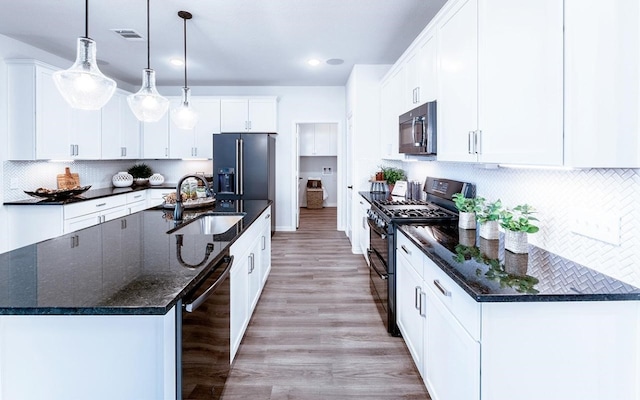 kitchen featuring hanging light fixtures, light hardwood / wood-style flooring, a kitchen island with sink, black appliances, and white cabinets