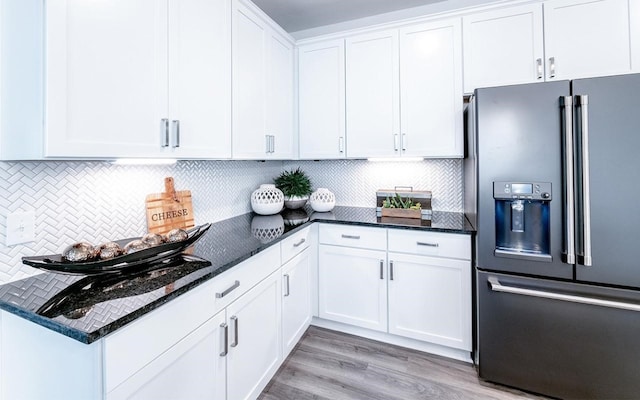 kitchen featuring light hardwood / wood-style flooring, high quality fridge, backsplash, and white cabinets