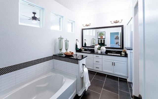 bathroom featuring a washtub, oversized vanity, double sink, ceiling fan, and tile floors