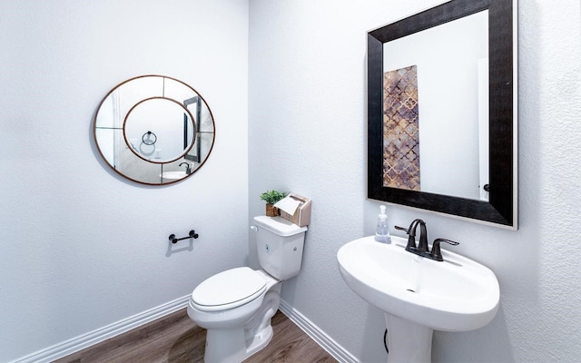 bathroom with toilet, hardwood / wood-style flooring, and sink