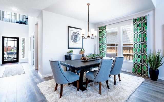 dining area with a notable chandelier, light hardwood / wood-style flooring, and a wealth of natural light