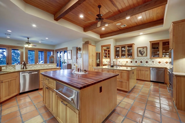 kitchen with a tray ceiling, wooden ceiling, a kitchen island, and appliances with stainless steel finishes