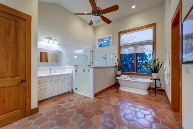 bathroom with tile flooring, separate shower and tub, vanity, ceiling fan, and vaulted ceiling