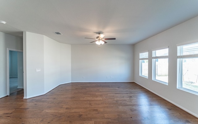 spare room with dark hardwood / wood-style flooring, ceiling fan, and a wealth of natural light