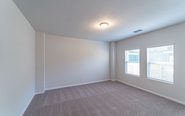 spare room with dark colored carpet