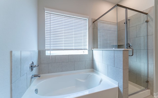 bathroom featuring plus walk in shower and a healthy amount of sunlight