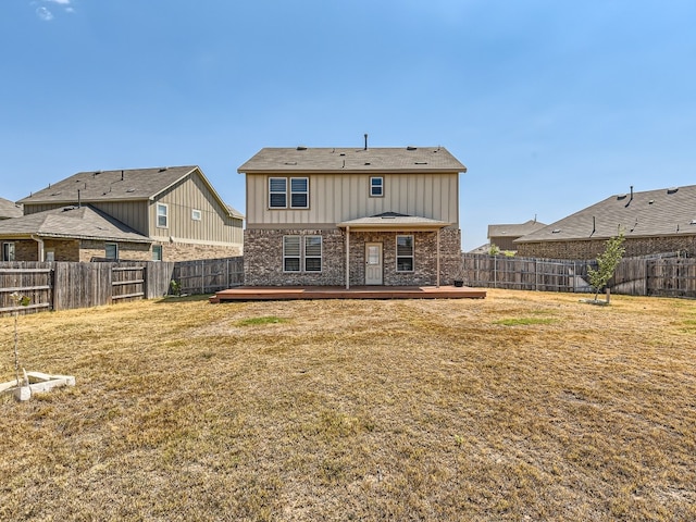 back of house with a wooden deck and a lawn