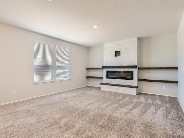 unfurnished living room with a fireplace and carpet