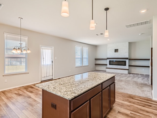 kitchen featuring a center island, decorative light fixtures, a chandelier, and light wood-type flooring