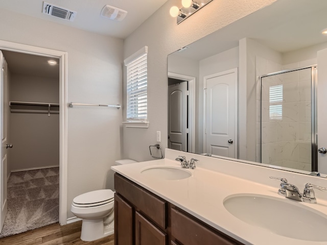 bathroom with double vanity, toilet, and hardwood / wood-style flooring