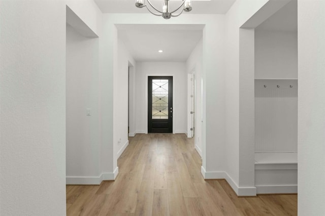 foyer entrance with a notable chandelier and light hardwood / wood-style floors