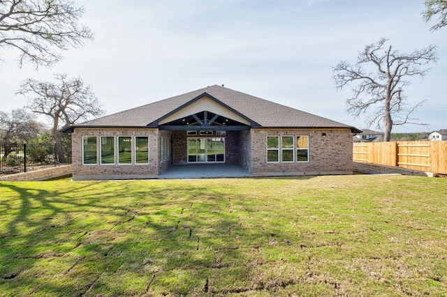 back of house featuring a patio and a yard