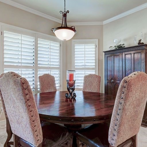 dining space featuring light tile floors and ornamental molding