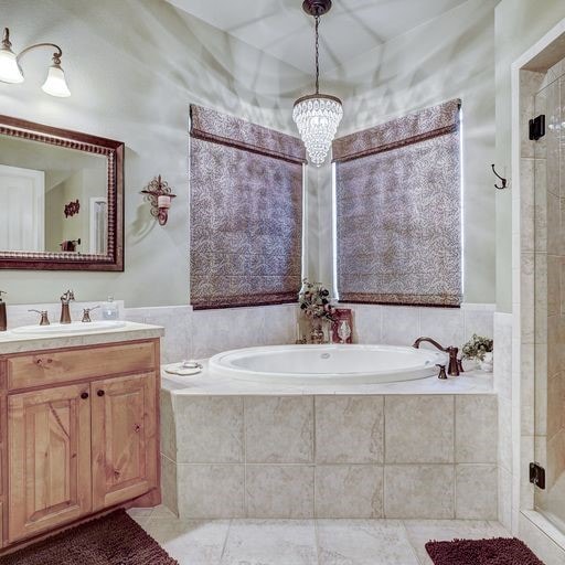 bathroom featuring tile floors, separate shower and tub, vanity, and a notable chandelier