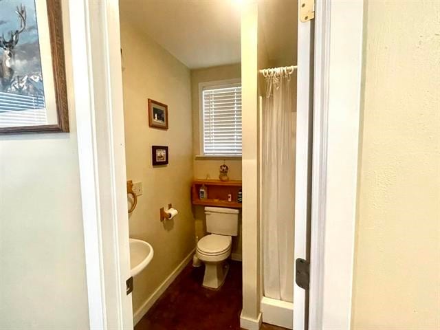 bathroom featuring a shower with shower curtain and toilet