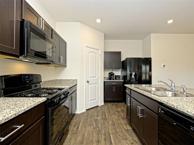 kitchen with dark wood-type flooring, sink, dark brown cabinets, and black appliances