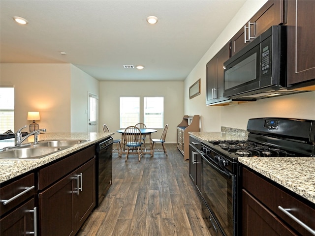 kitchen featuring sink, dark wood-type flooring, dark brown cabinets, light stone counters, and black appliances