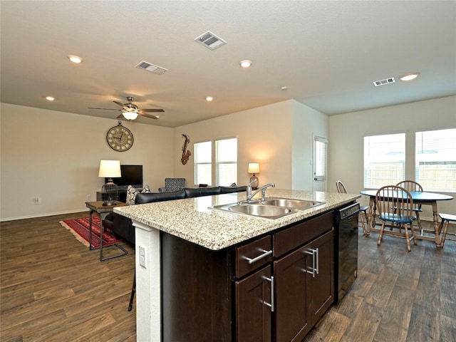 kitchen featuring an island with sink, dark hardwood / wood-style floors, black dishwasher, and sink