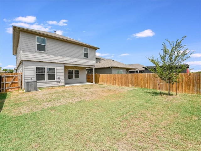 rear view of property featuring a yard and central AC