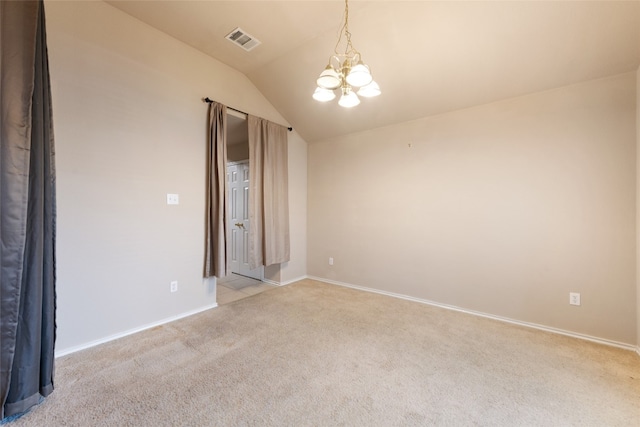 spare room featuring lofted ceiling, light colored carpet, and an inviting chandelier