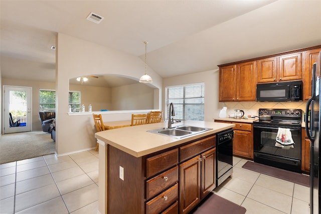 kitchen with an island with sink, light tile floors, tasteful backsplash, black appliances, and sink