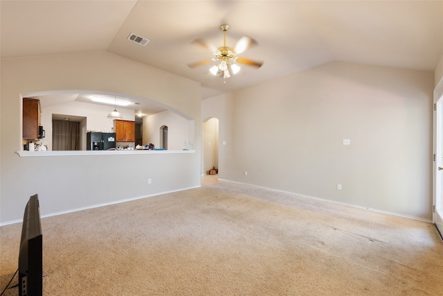 unfurnished living room featuring lofted ceiling, light colored carpet, and ceiling fan