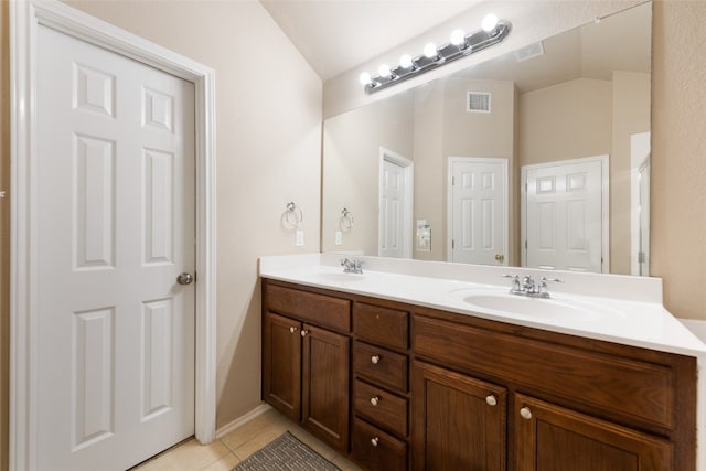 bathroom with dual bowl vanity, tile flooring, and vaulted ceiling