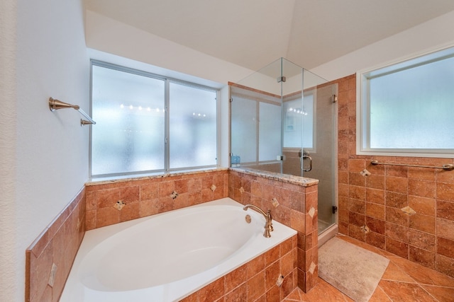 bathroom featuring tile flooring and separate shower and tub