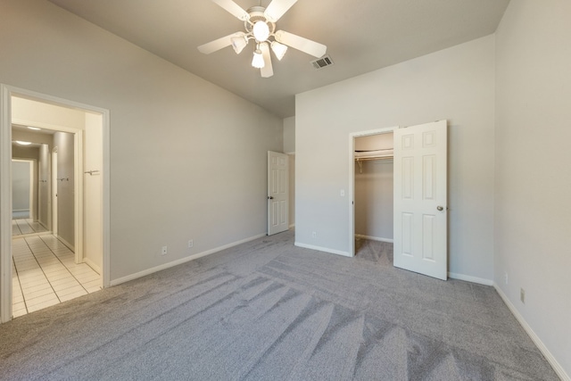 unfurnished bedroom featuring a closet, light tile flooring, ceiling fan, and lofted ceiling