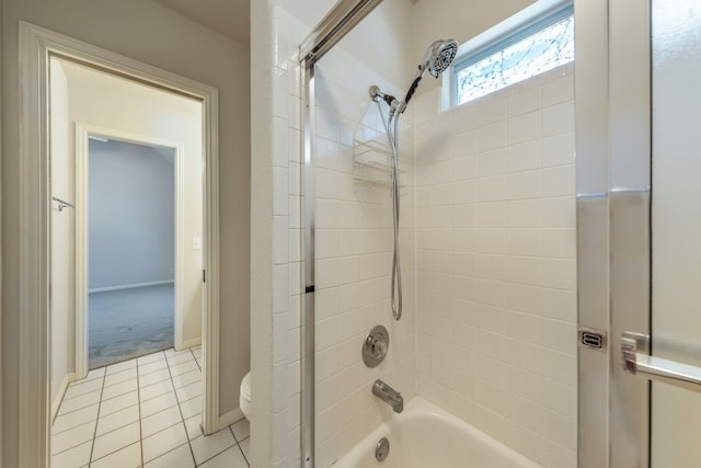 bathroom featuring tile flooring, toilet, and tiled shower / bath combo