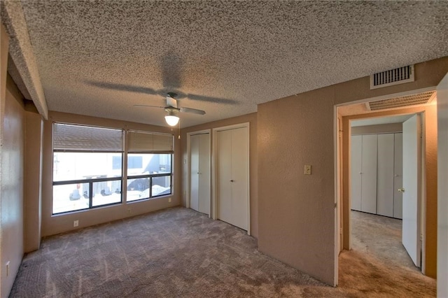 unfurnished bedroom featuring ceiling fan, carpet, and a textured ceiling