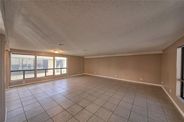 tiled empty room with a textured ceiling