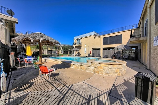 view of pool with a community hot tub and a patio area