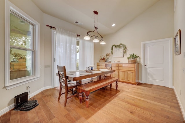 dining area with plenty of natural light, light hardwood / wood-style floors, and vaulted ceiling