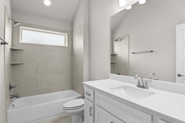 full bathroom with tiled shower / bath, vanity, and toilet