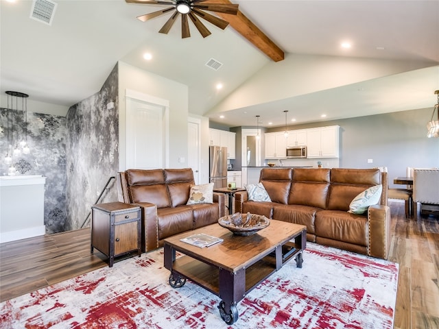 living room featuring beam ceiling, light wood-type flooring, and high vaulted ceiling