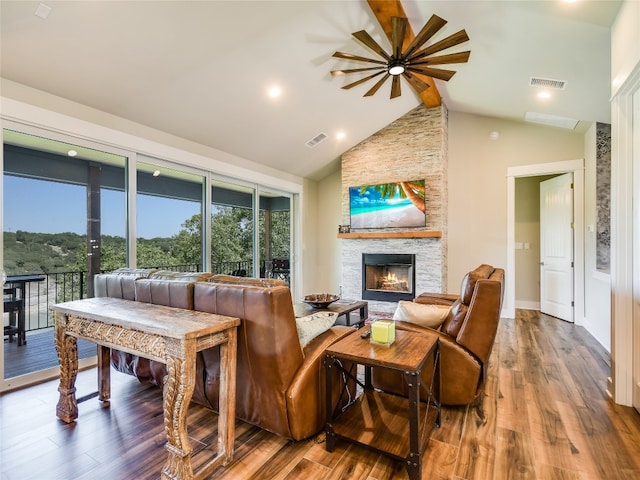 living room featuring dark hardwood / wood-style flooring, beam ceiling, a stone fireplace, and high vaulted ceiling