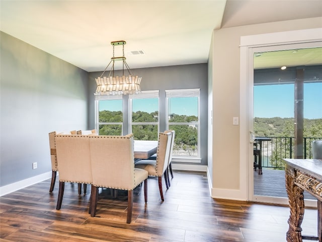 dining area with dark wood-type flooring and a chandelier