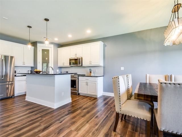 kitchen featuring dark wood-type flooring, stainless steel appliances, decorative light fixtures, sink, and white cabinetry