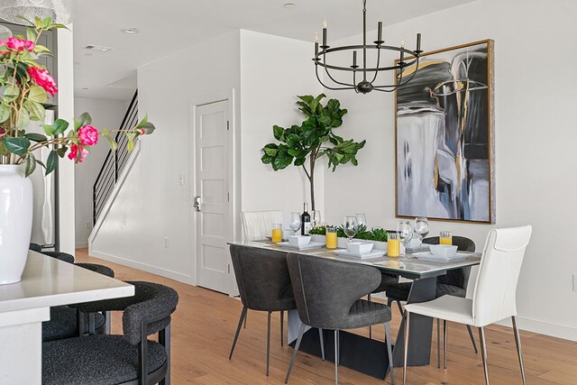 dining room with an inviting chandelier and light wood-type flooring