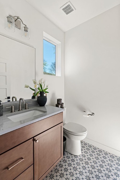 bathroom with vanity, tile floors, and toilet