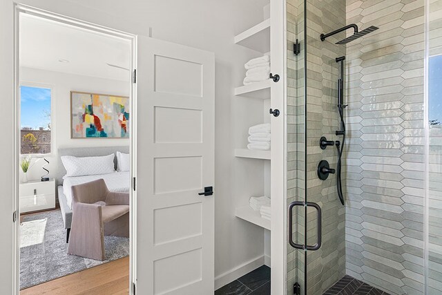 bathroom with a shower with shower door and wood-type flooring